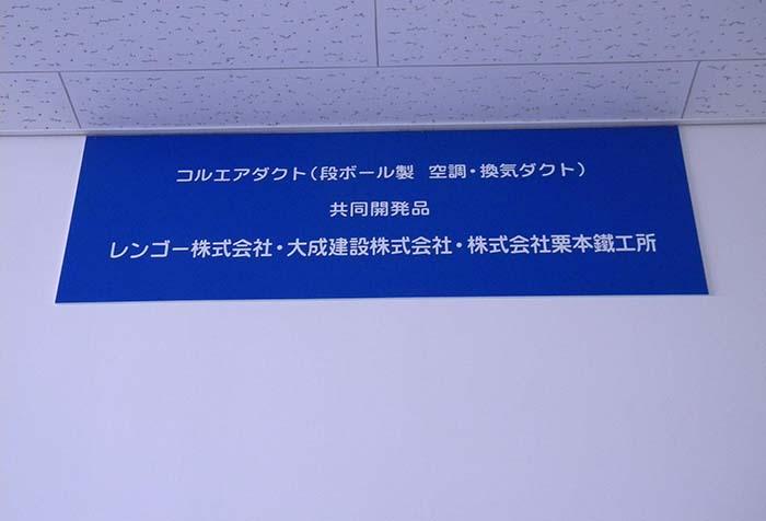 管理棟の壁面には三社の共同開発を記念したタブレット