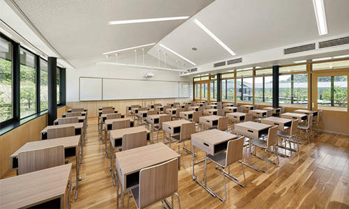 緩やかな円弧を描く切妻天井と、緑に包まれる教室